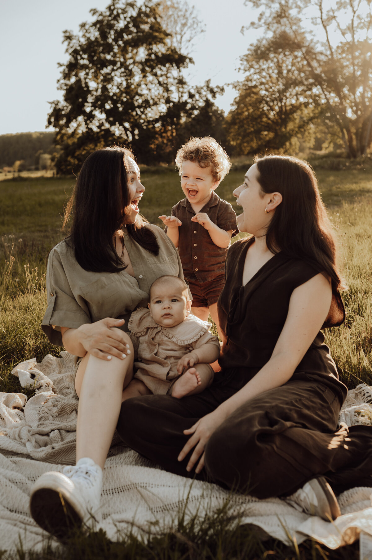 Familiefotoshoot in het gras tijdens zonsondergang