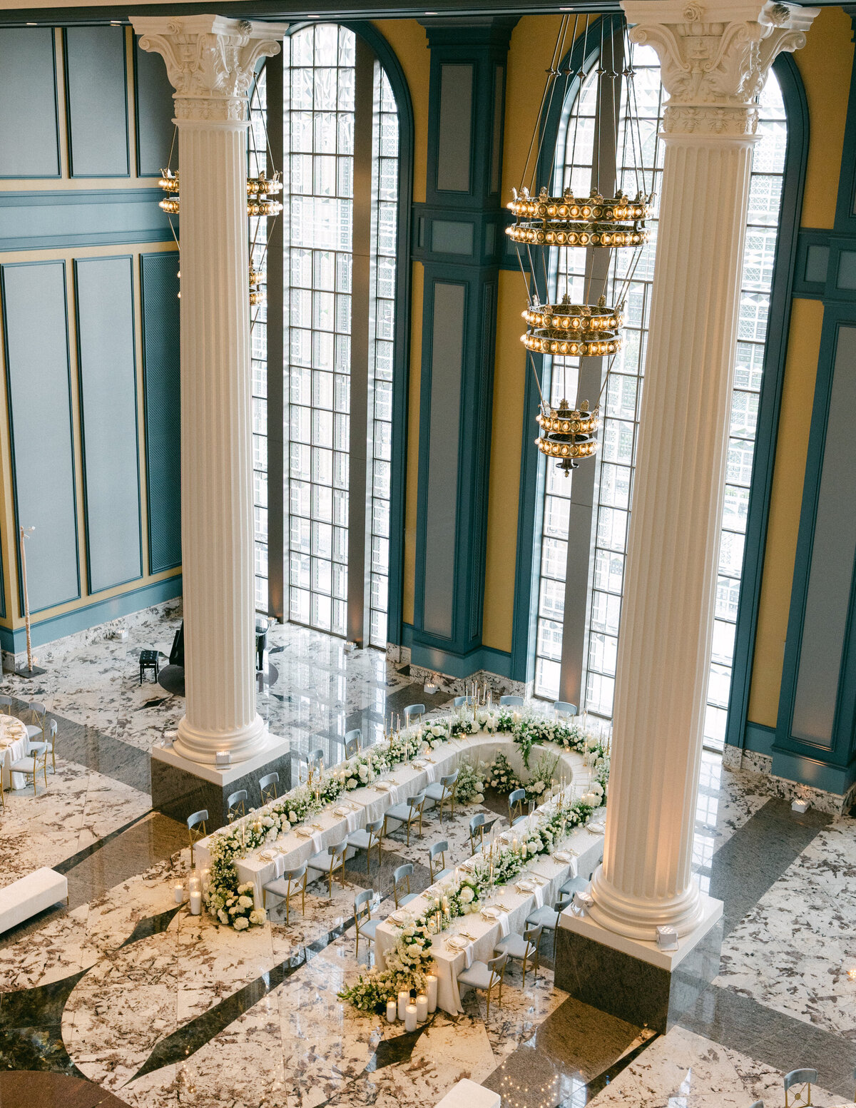 overview of black tie gold and white wedding with flower garland spilling onto ground