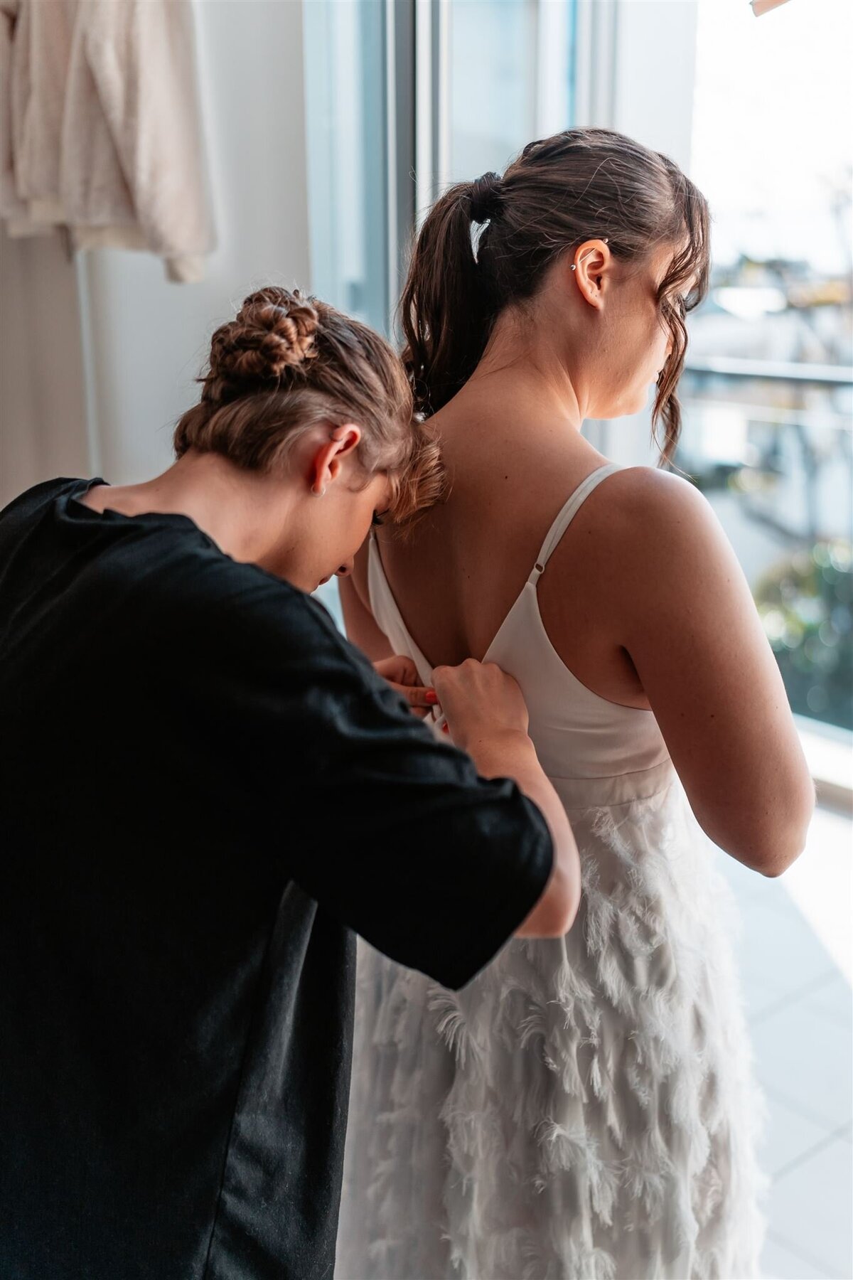 Hannah's bestfriend is helping her wear her beautiful wedding dress