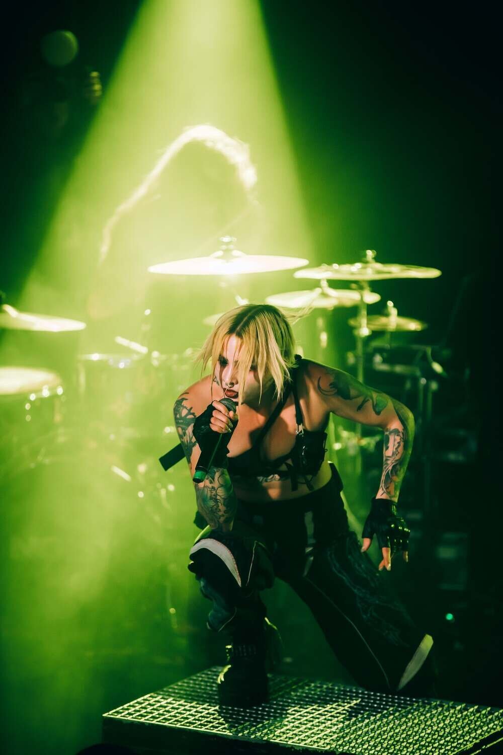 Mimi Braks kneels on stage at XOYO