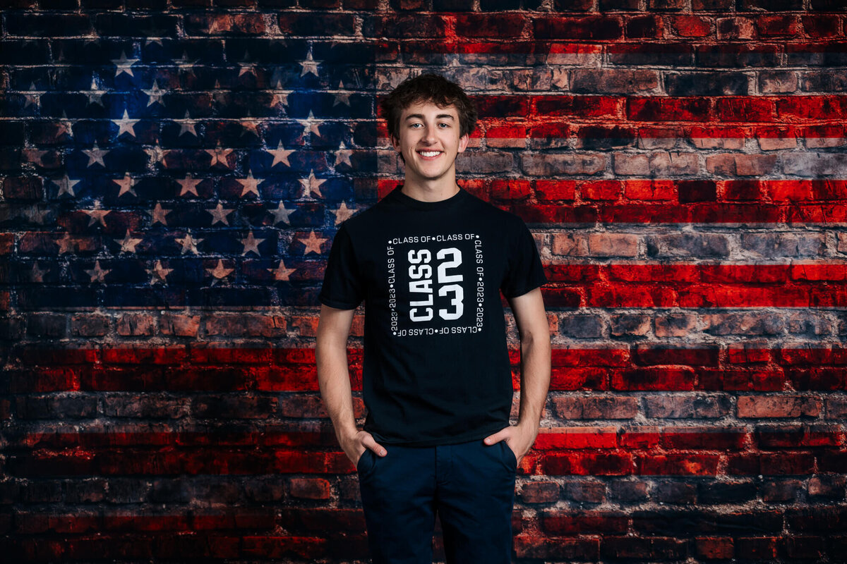 Boy poses in front of American Flag brick wall for Prescott senior photographer Melissa Byrne