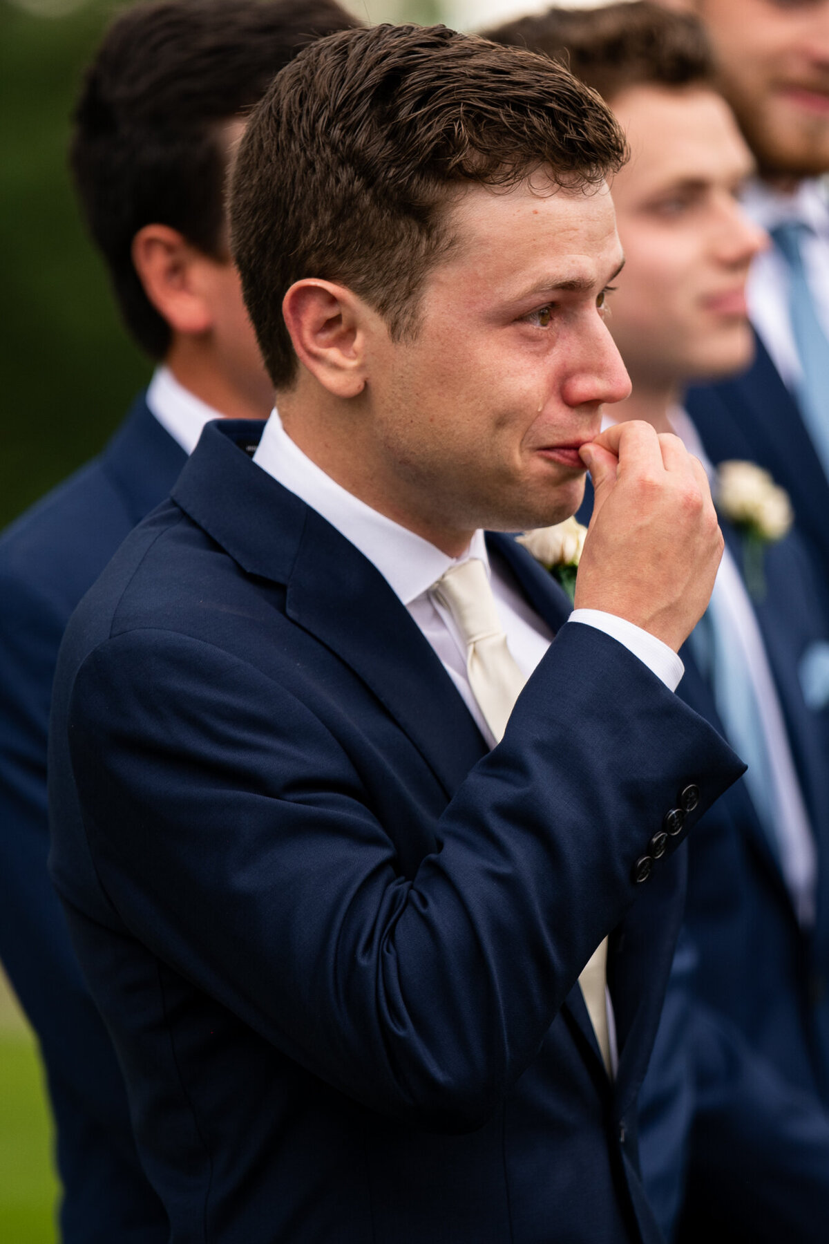 Groom sees his bride walking up the aisle and sheds tears of joy