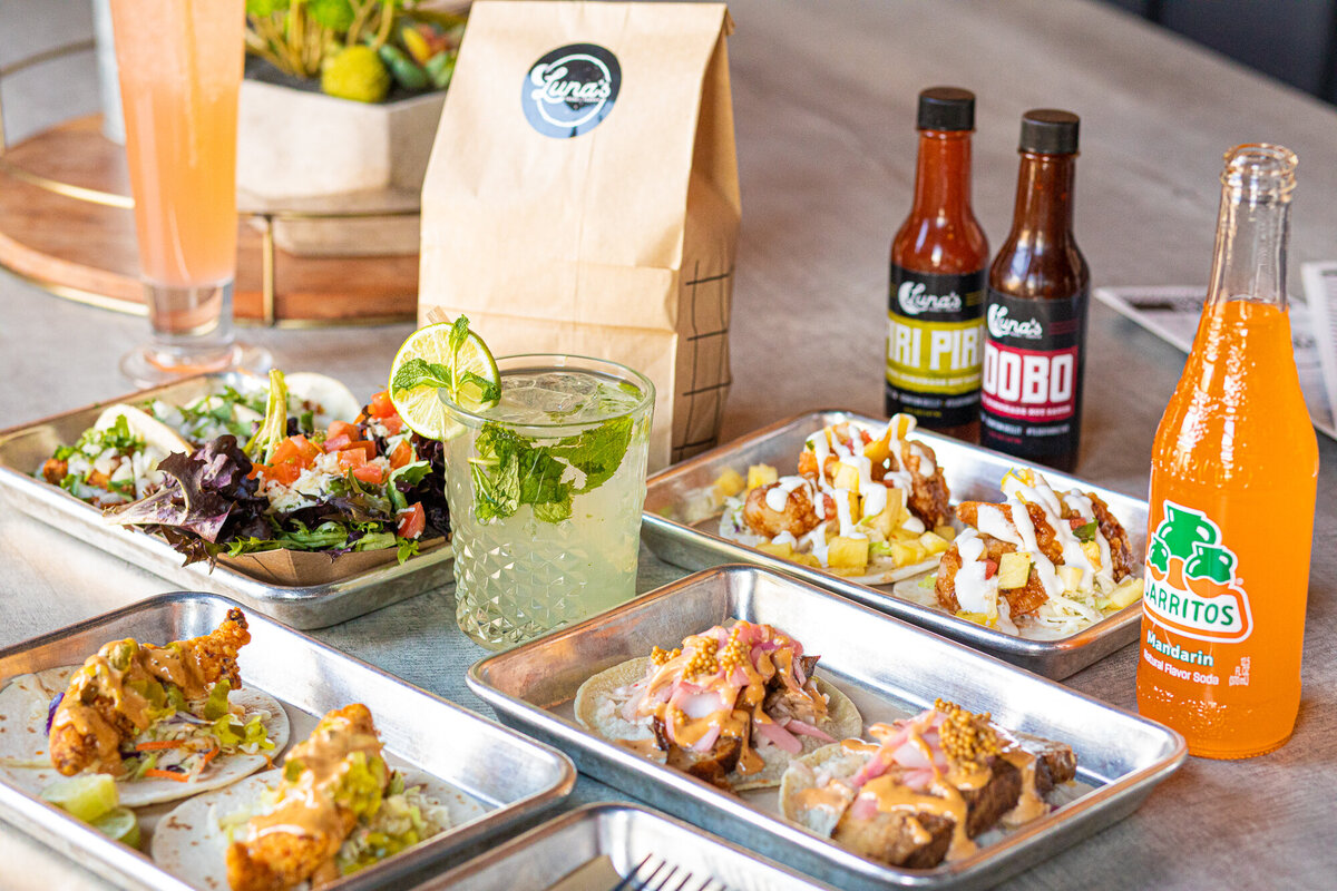 An array of tacos and cocktails sits on a table at Luna's Tacos and Tequila.
