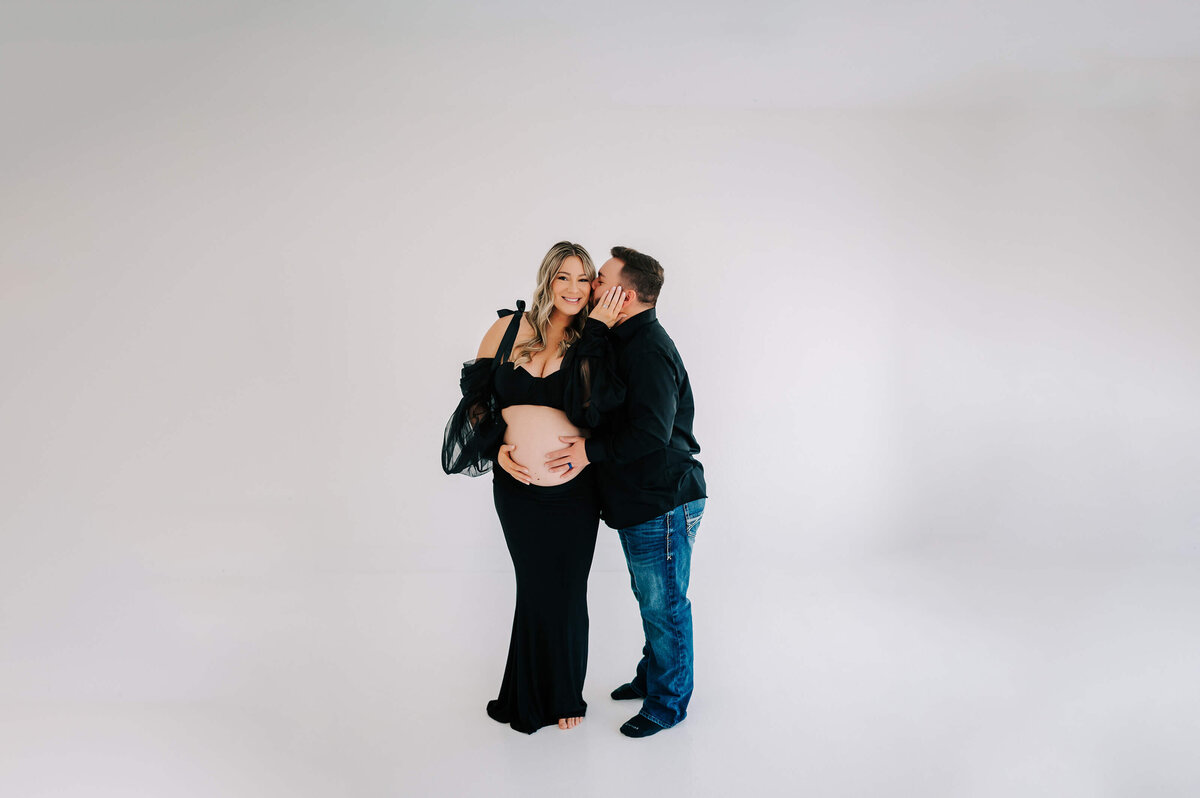 husband kissing pregnant mom on cheek during Branson MO maternity photography session