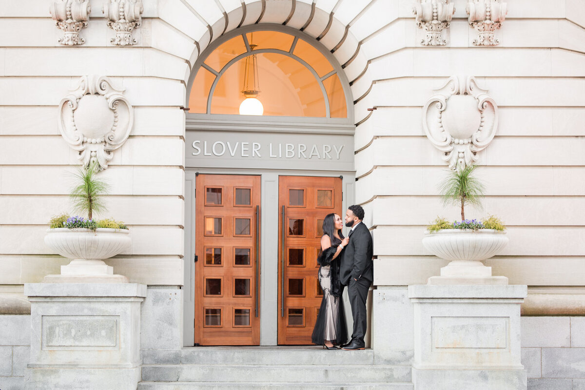 Black couple during their engagement session in front of library doors by Virginia Beach Wedding Photographer Vinluan Photography