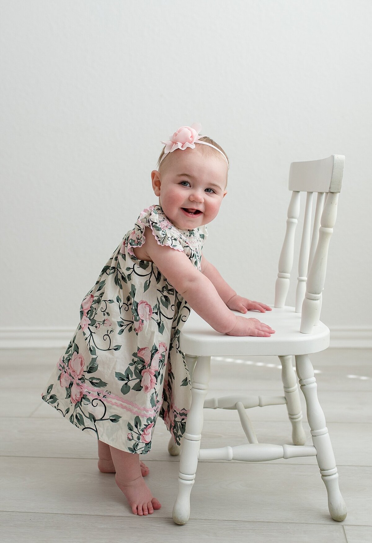 baby standing holding on to a chair