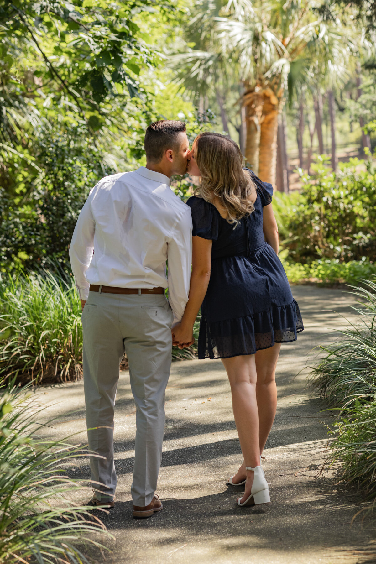 engaged couple kissing along walkpath at Mobile Botanical Gardens by Mobile Alabama wedding photographer Amanda Richardson Photography
