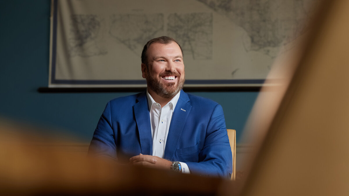 A man smiling while sitting at a table