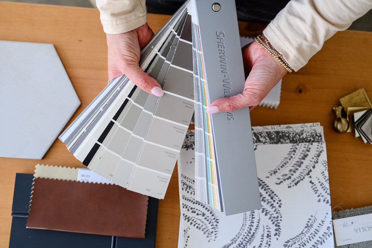 A denver product photographer takes a stock image during a branding photography session for an interior designer of paint chips and design materials for a home remodel.