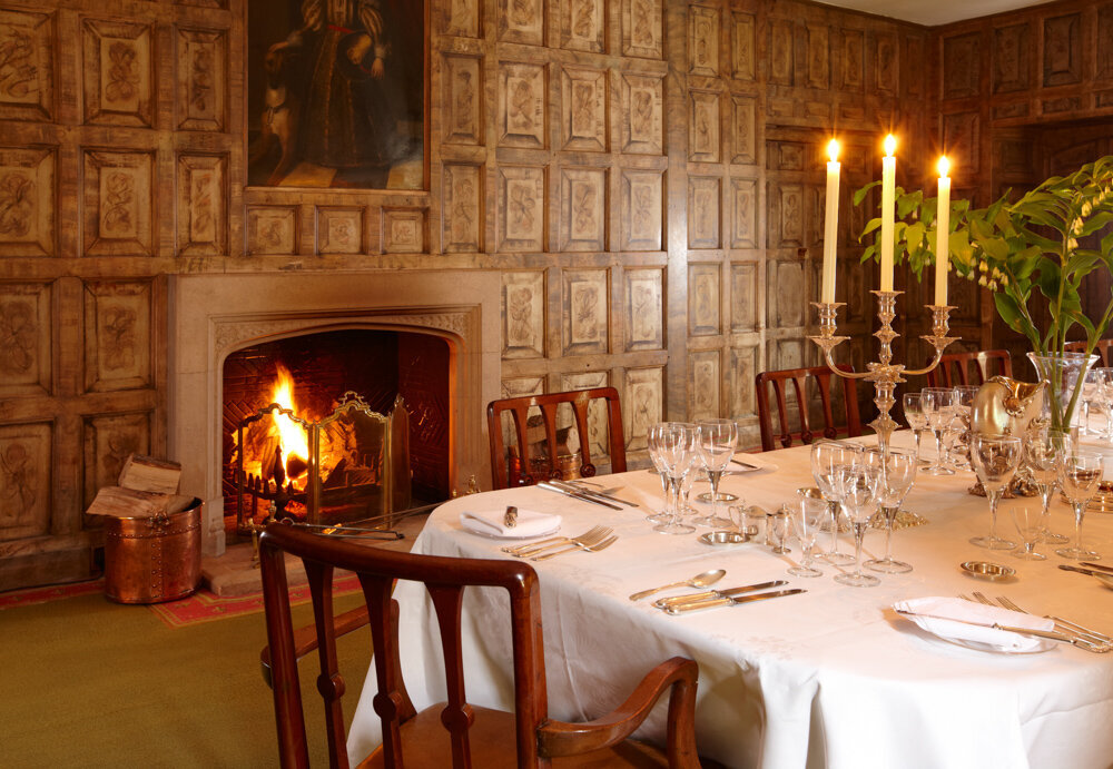 Wood panelled room with open fire place and long banquet style table