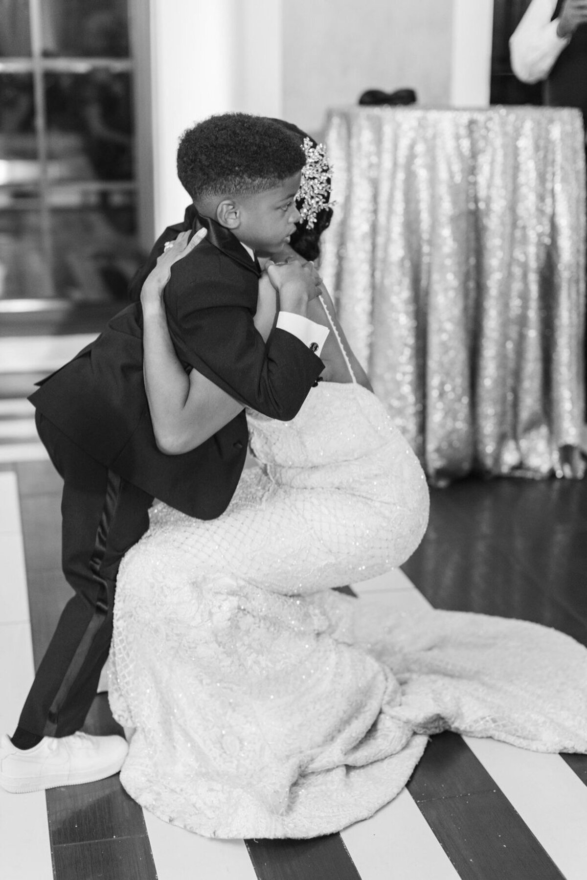 black and white photo of son hugging mother on her wedding day