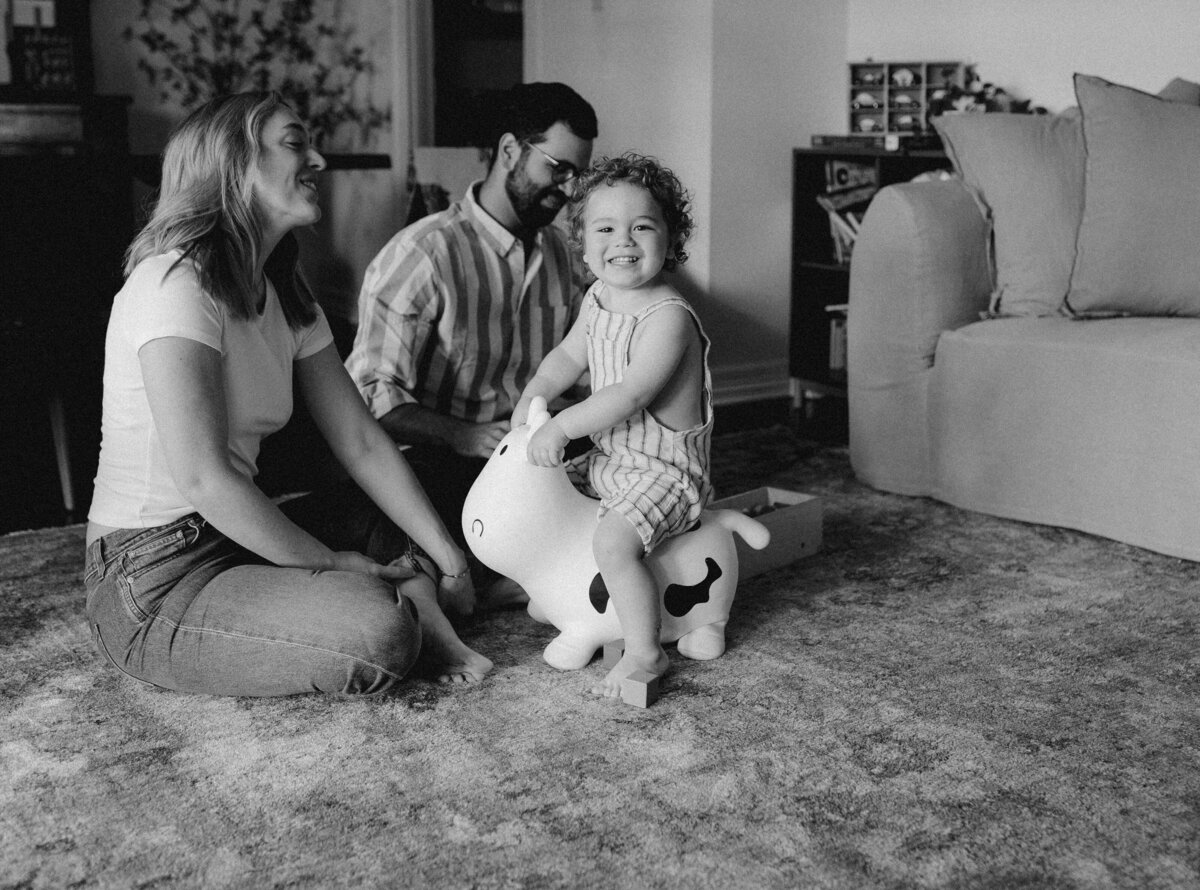 Toddler wearing undies  lying on top of mother with abstract art behind them