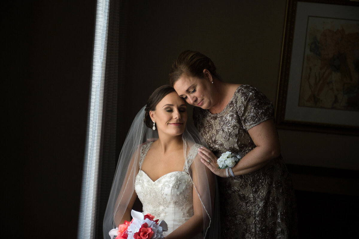 Mom hugging bride on wedding day.