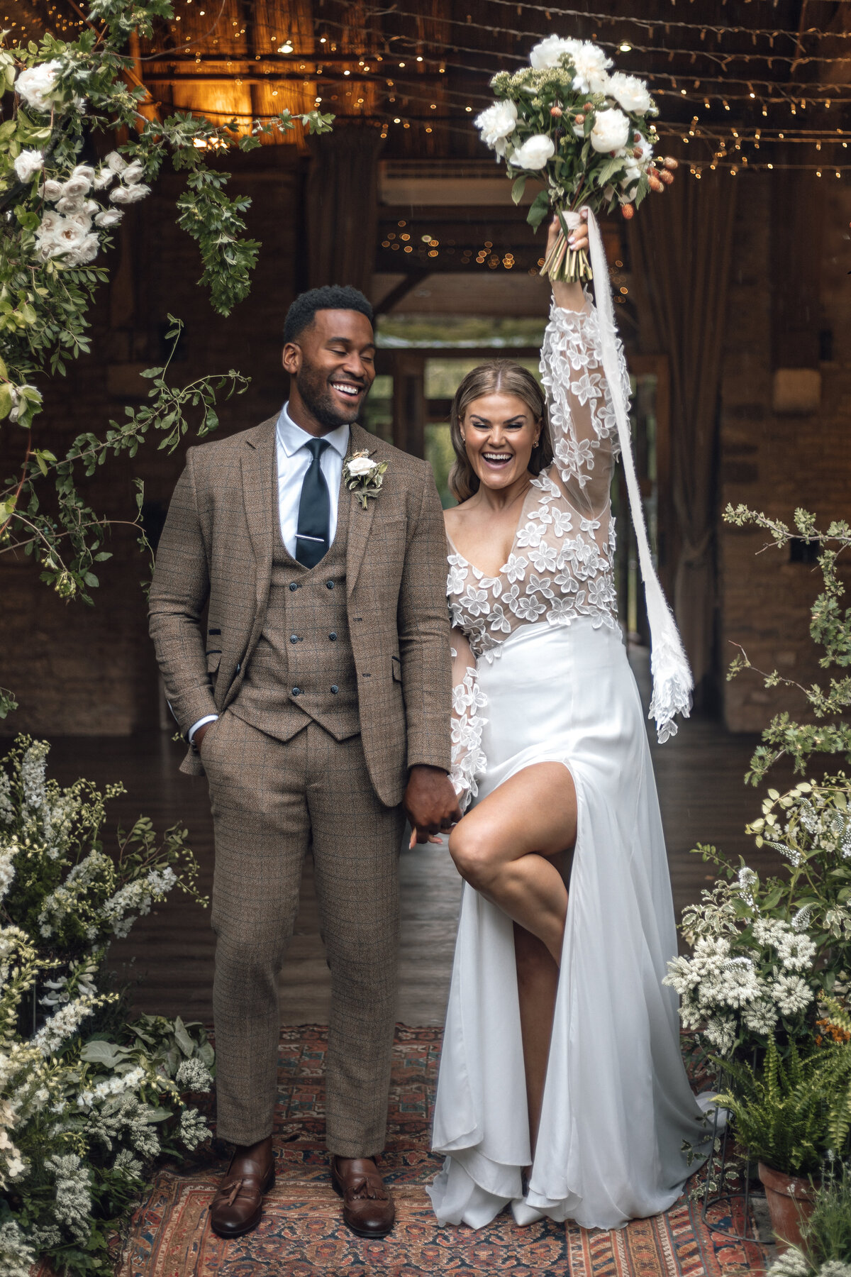 A wedding photographer captures the moment a bride and groom kiss during their first dance outside in the venue grounds.