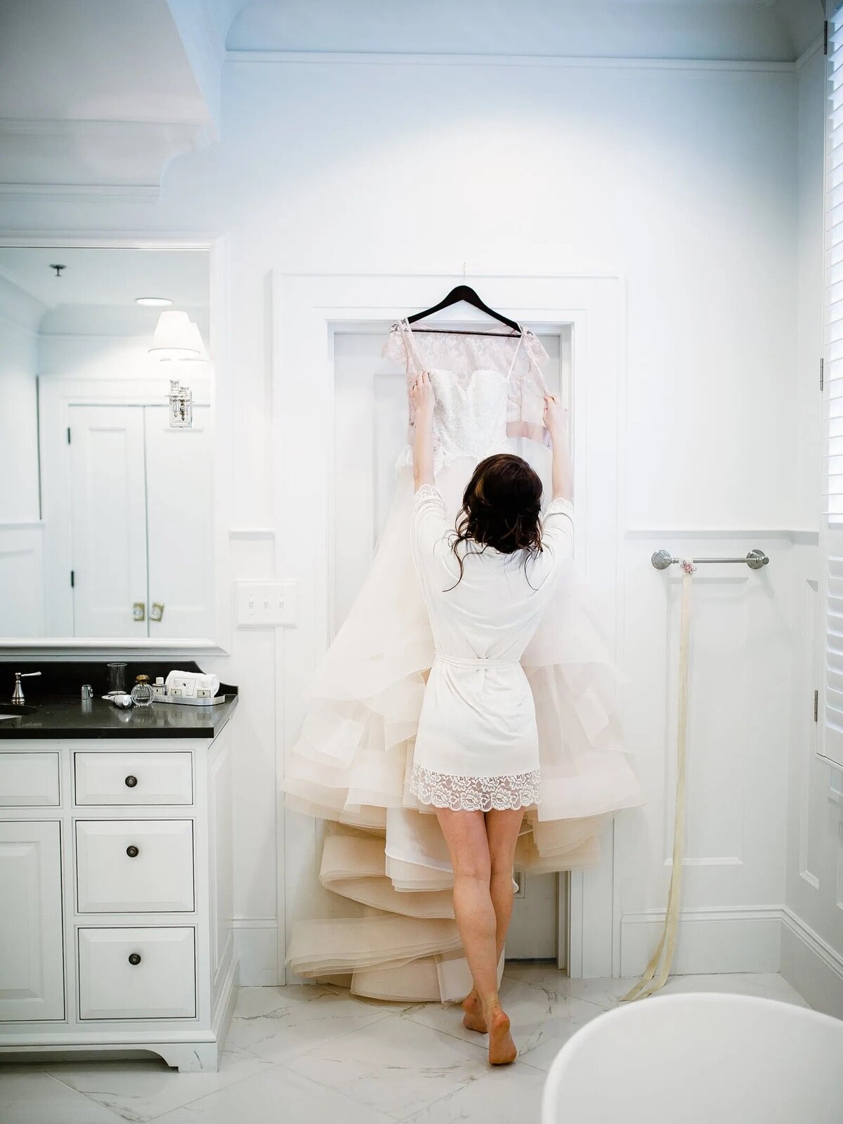 a bride taking her dress off of a hanger.