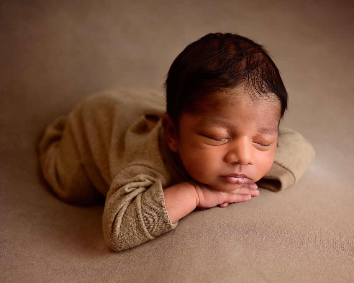 Kitsap newborn session with newborn posed sleeping on his belly with his hands under his chin. Image  by E. Benecki Photography.