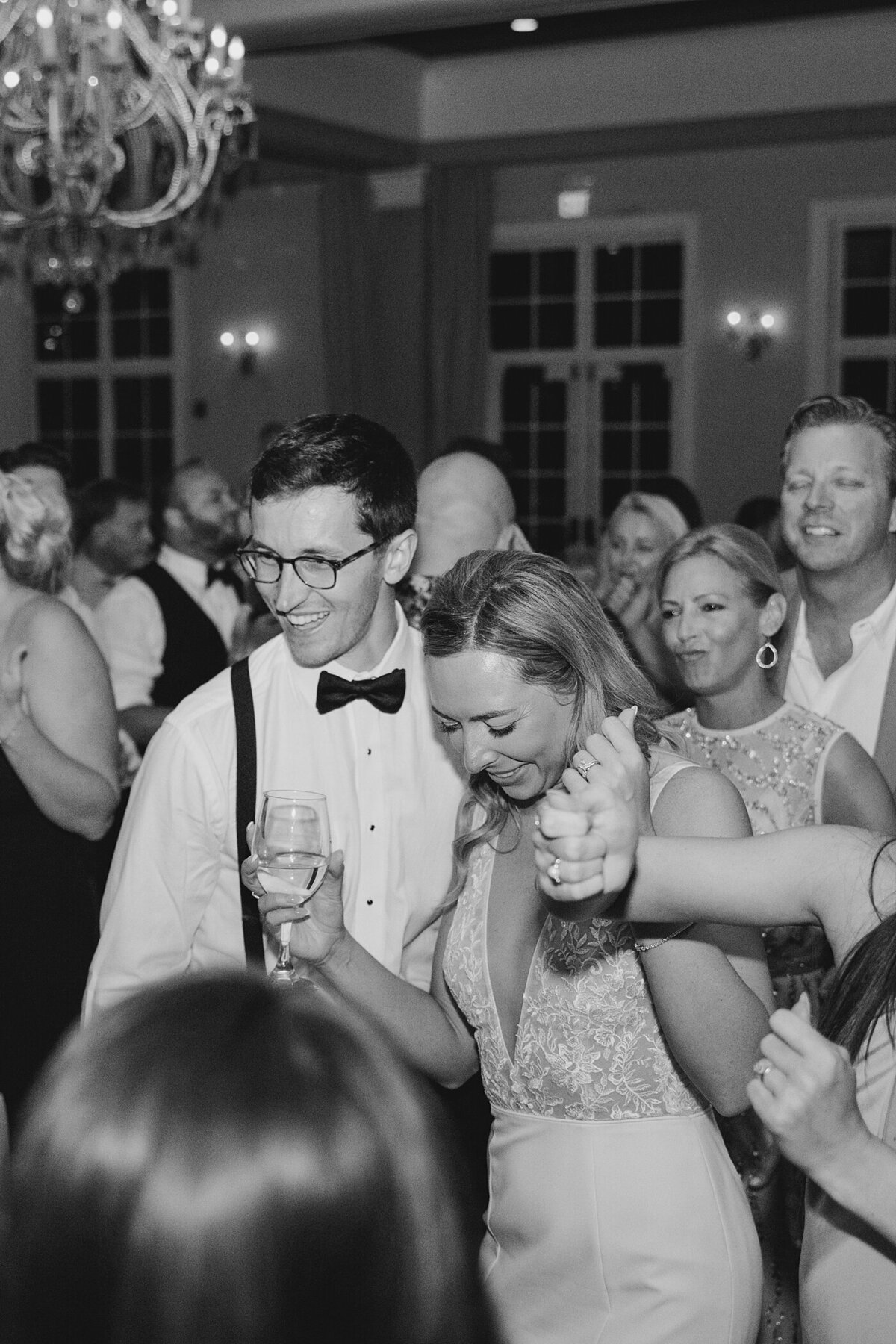 black and white wedding reception picture of the bride and groom dancing with their guests