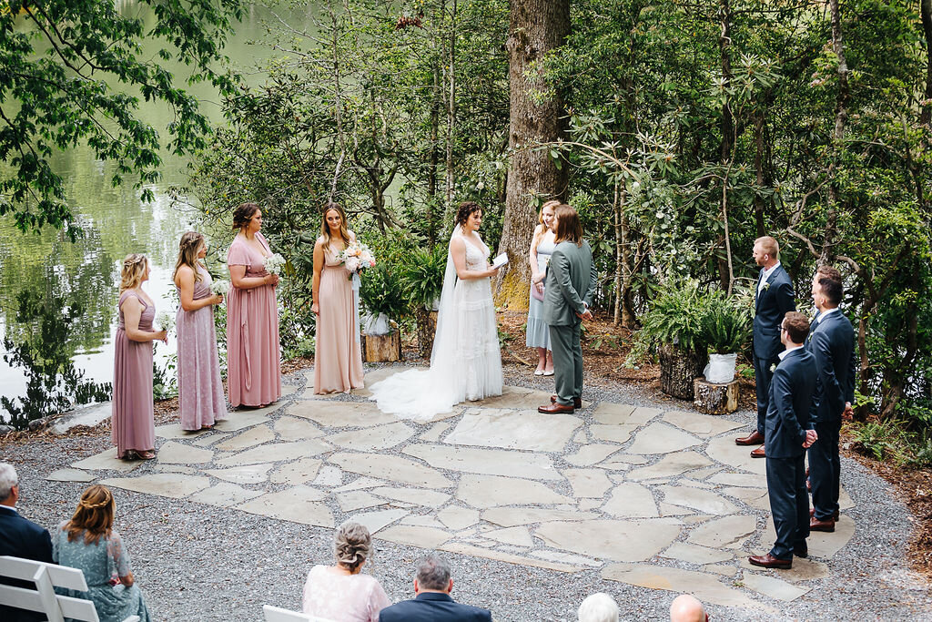 bridesmaids and groomsmen gathered around bride and groom at outdoor wedding
