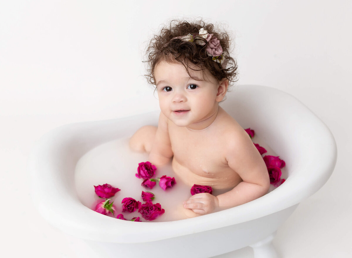 Baby girl  sitting in the  mil bath with fresh flowers for 1st  Birthday  photoshoot in NYC 