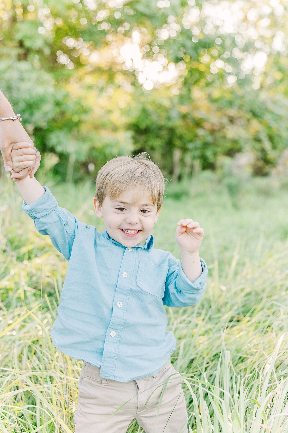 boy holds moms hand duirng fall family photo session with Sara Sniderman Photography in Natick Massachusetts