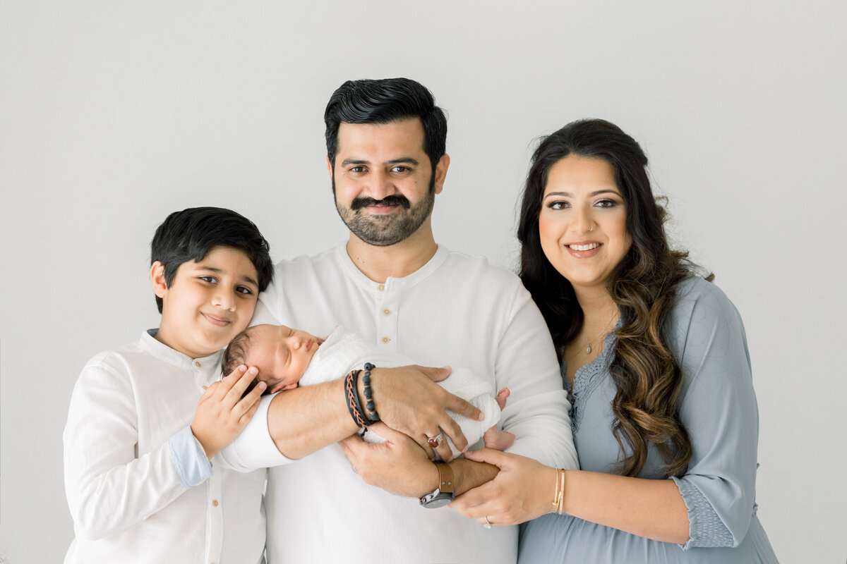 a family posing with a newborn baby