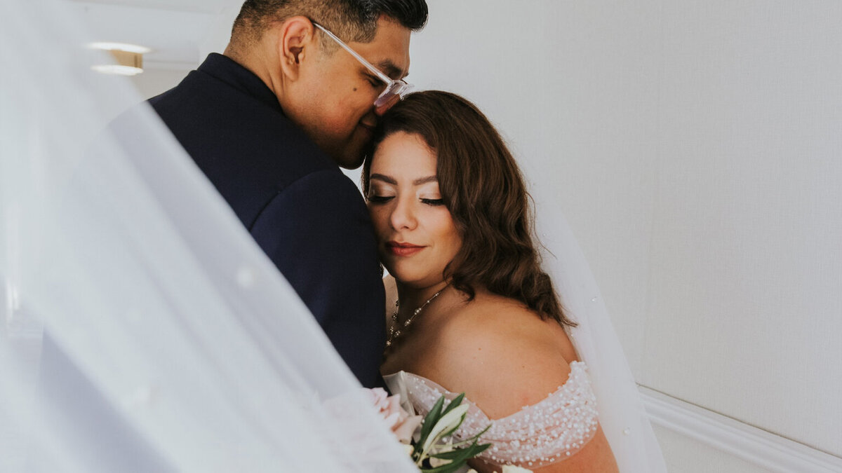 bride and groom posing intimately inside luxurious venue