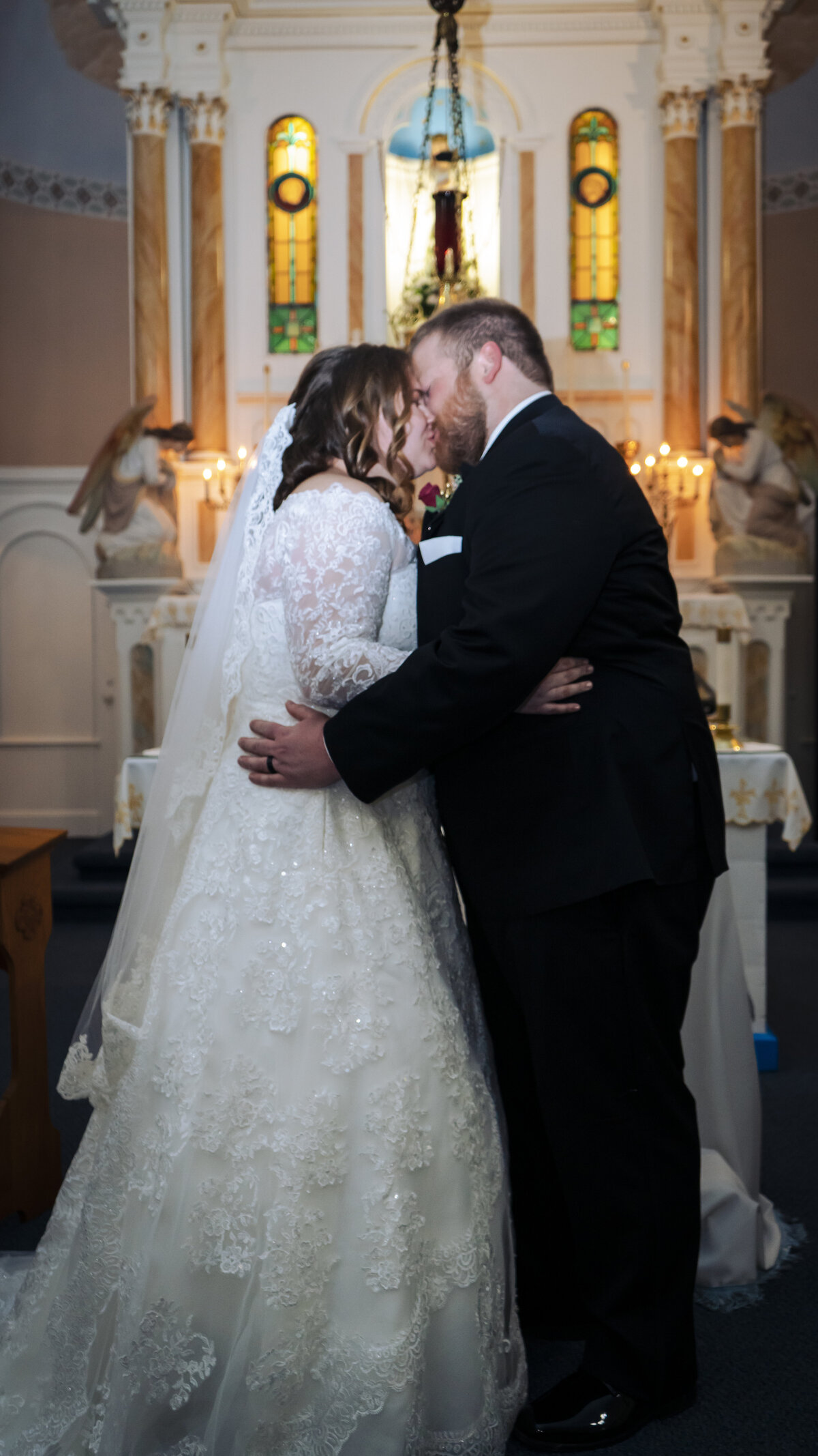 Photo of a bride and groom kissing at the altar