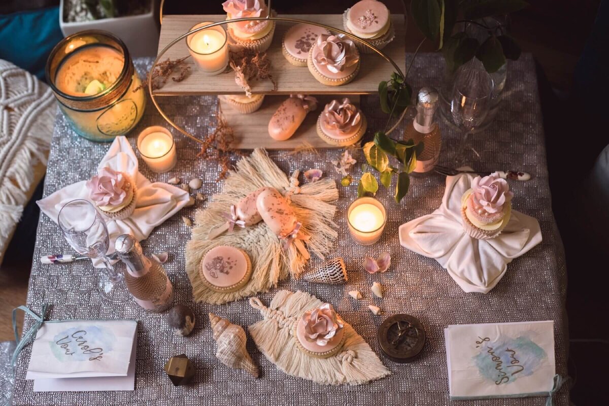 Beautiful table set up with candles, biscuits, cupcakes and cake pops