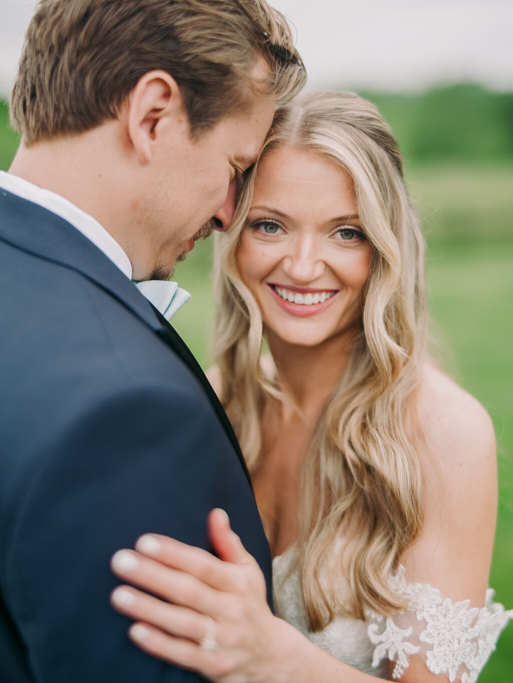 Bride smiling while hugging her groom