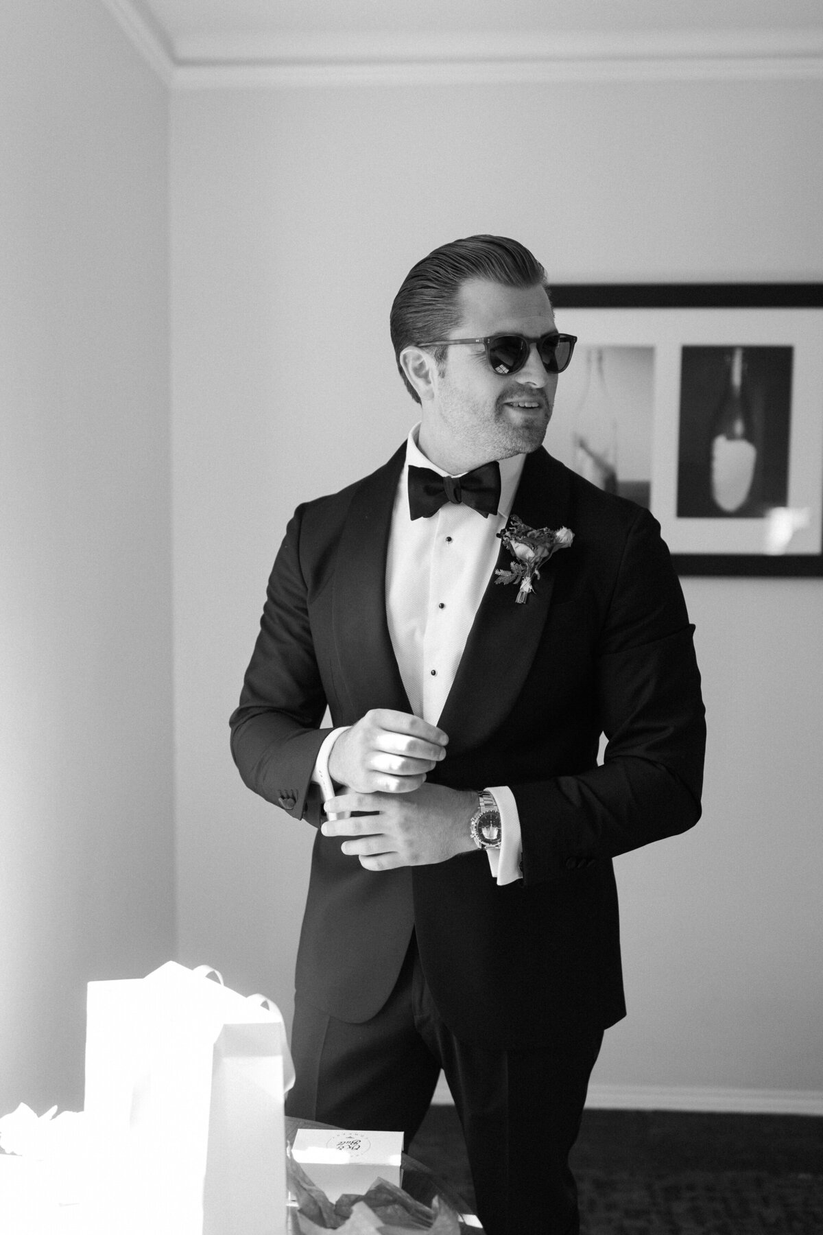 Groom adjusts his cuff links when getting ready 