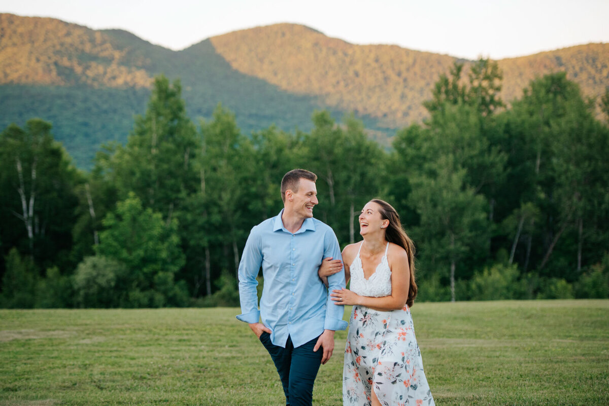 engaged couple laughing and walking at mountain top inn chittenden