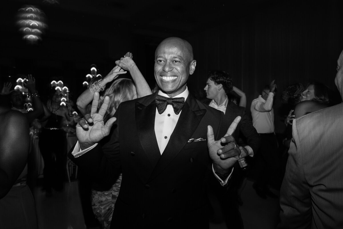 A father of the bride in black and white cuts loose on the dance floor at his daughters wedding