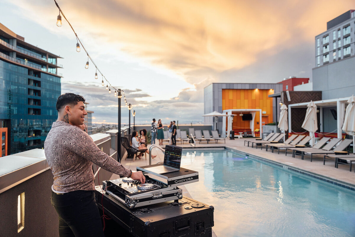 DJ working a party on the pool deck with guests lounging in the seating enjoying cocktails
