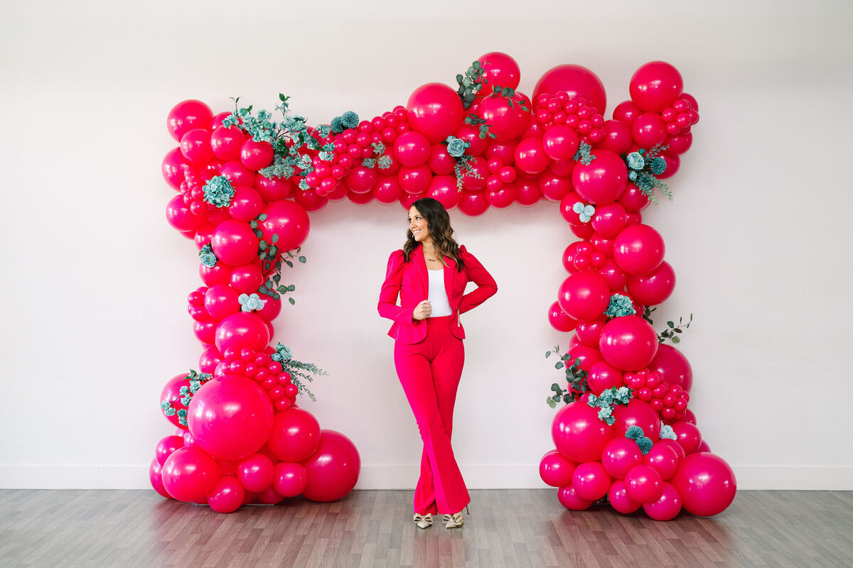 Air with Flair Decor expert in branded outfit showcasing popular balloon backdrops rentals in Raleigh for stylish event decorations.