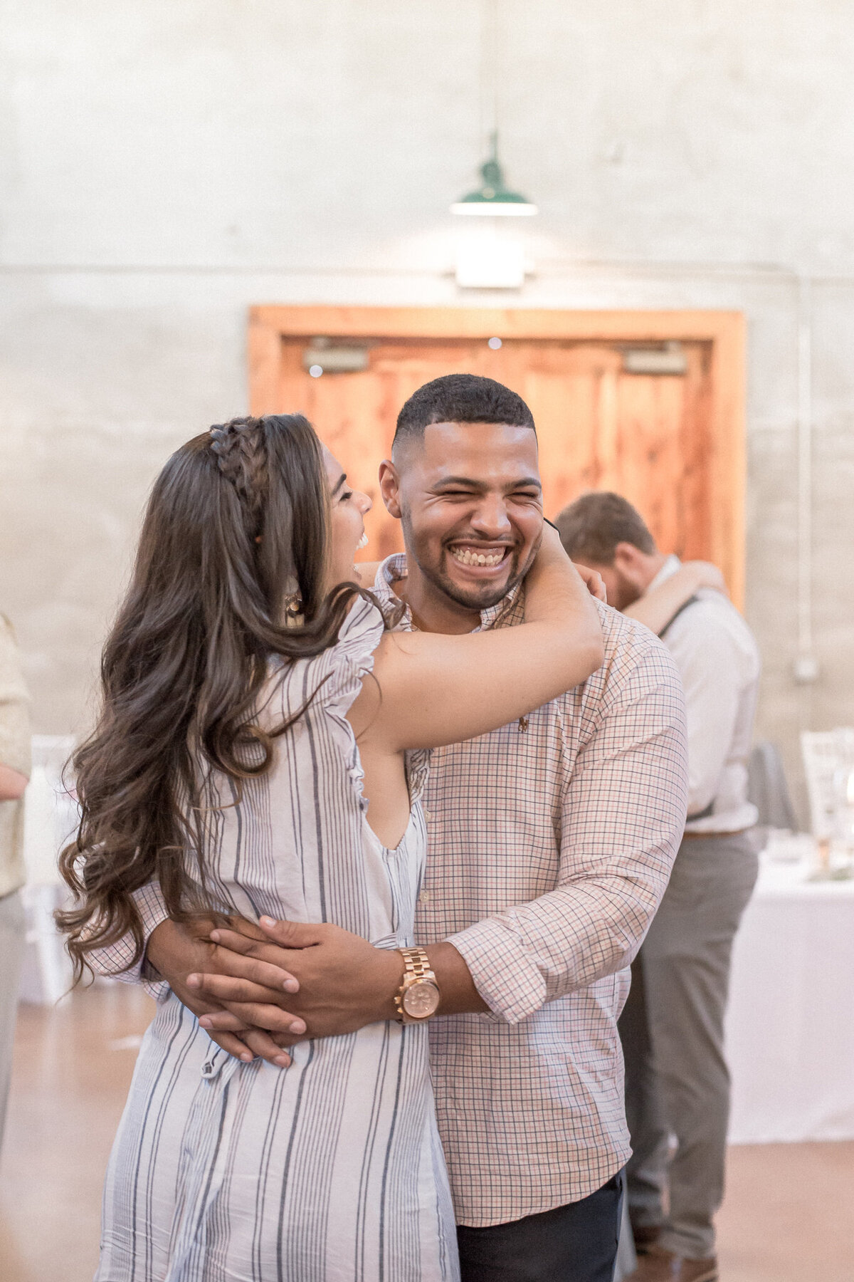 A couple, with exuberant smiles, dance, holding each other tightly
