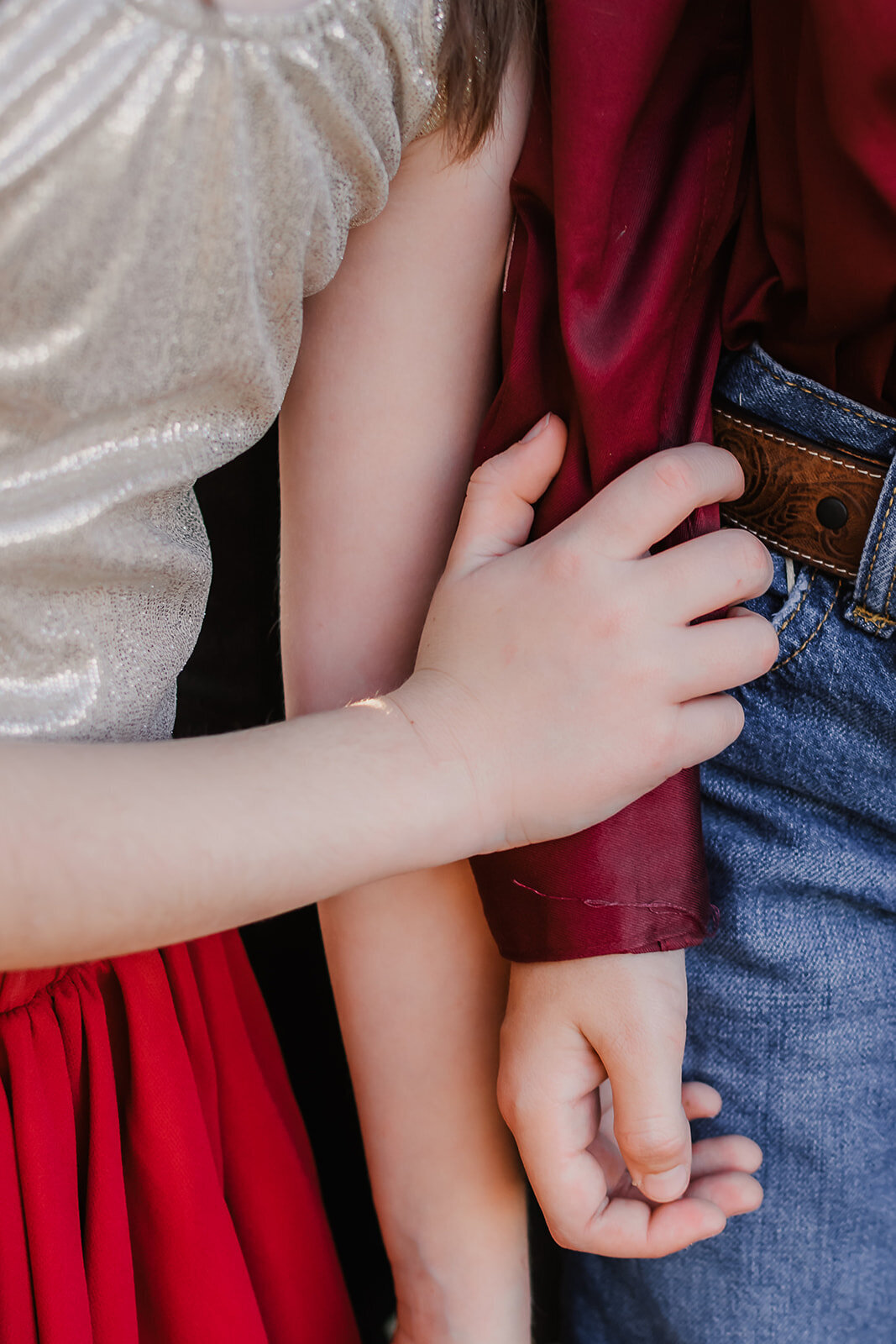 Sister embracing brother's arm.