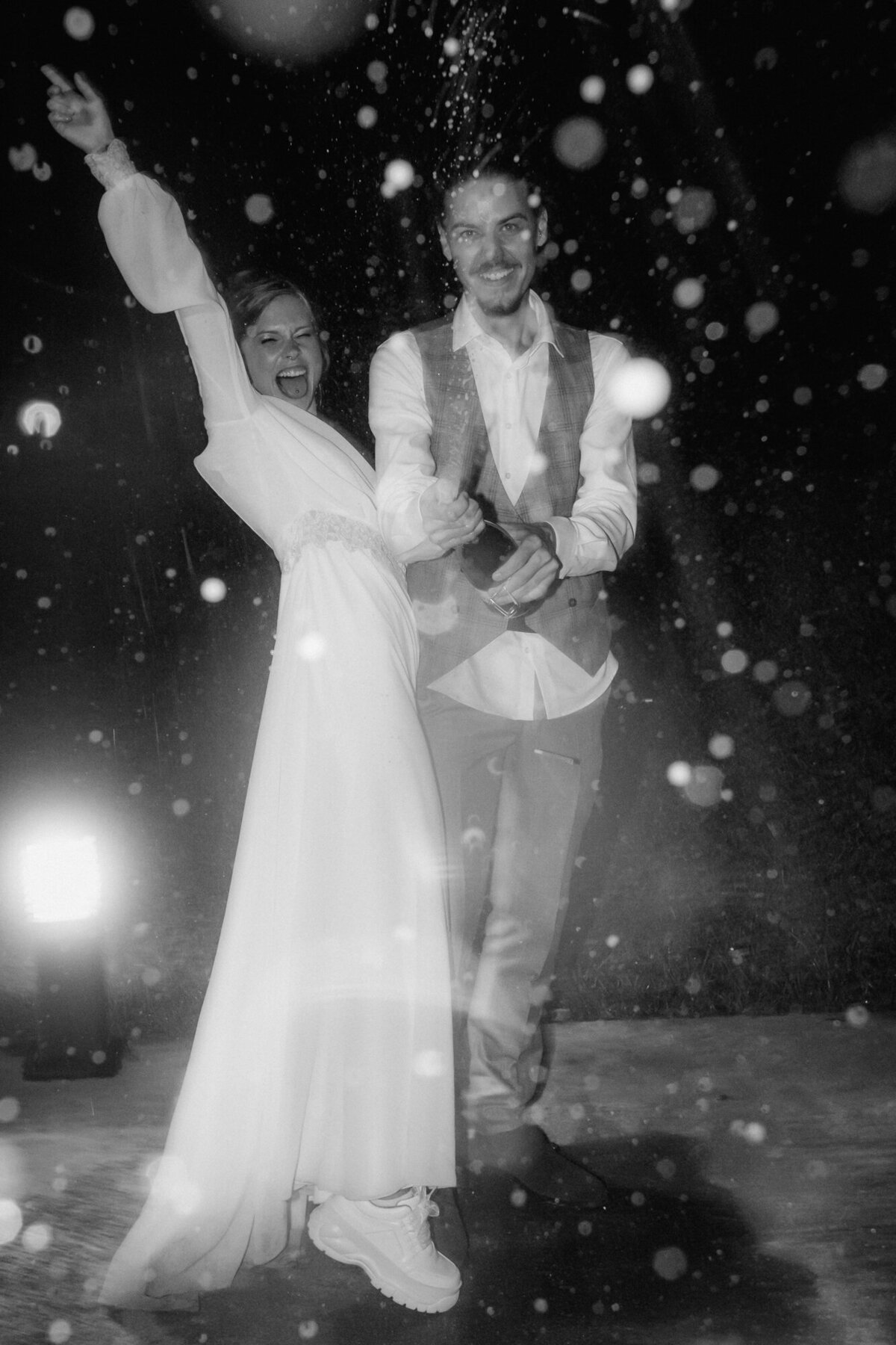 Bride and groom celebrate their big day with spraying champagne.