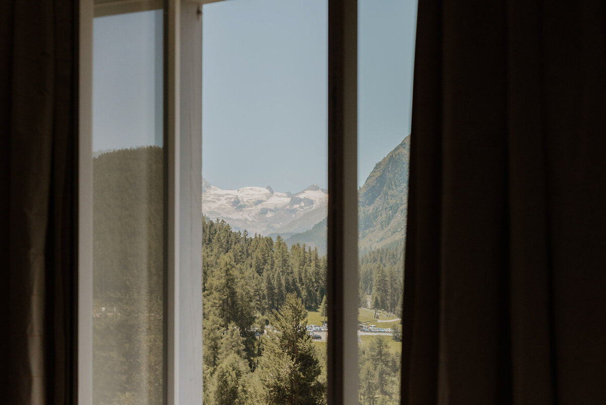 Mountain landscape through hotel window, wedding morning by Vienna Photographer