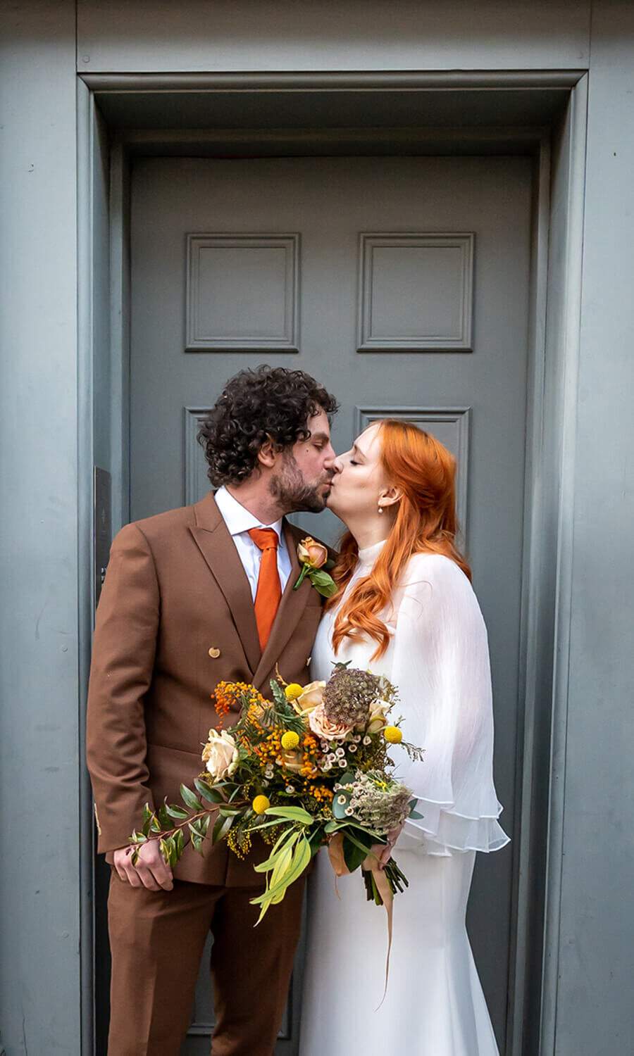 Bride and groom kissing in doorway of Exmouth market house.