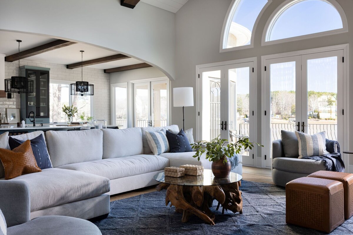 family room with large windows, leathers poofs, and a large white sofa