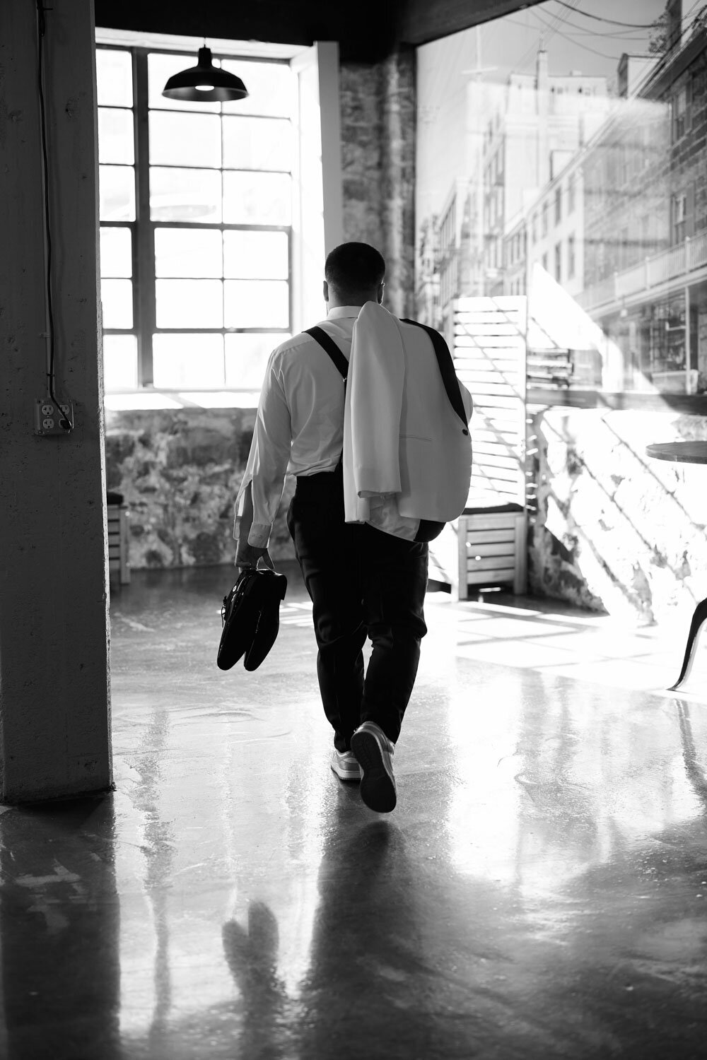 Back pose of the groom bringing his suite with him