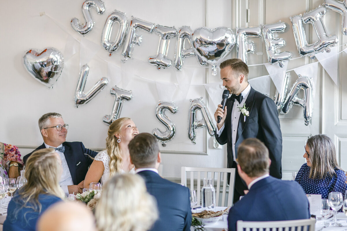 Brudgum håller tal till bruden i matsalen på Schenströmska
