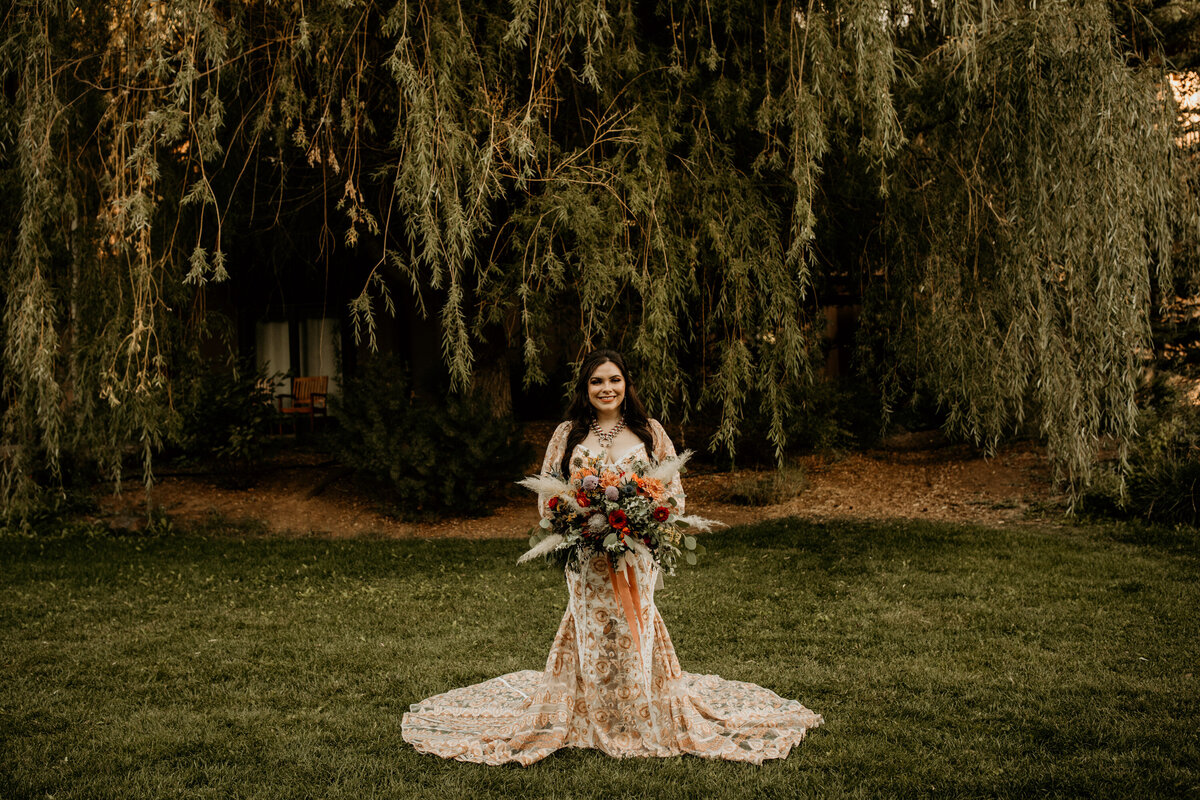 bride standing in her peach lace wedding dress