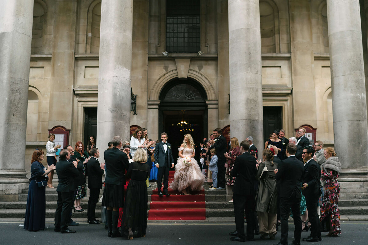 A bride and groom with all of their guests outside the church.