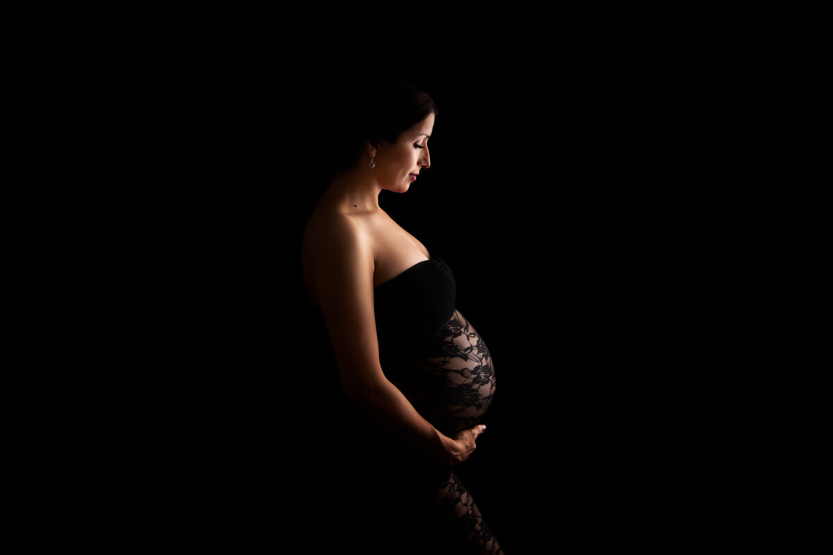 Pregnant woman dressed in black lace fitting dress
