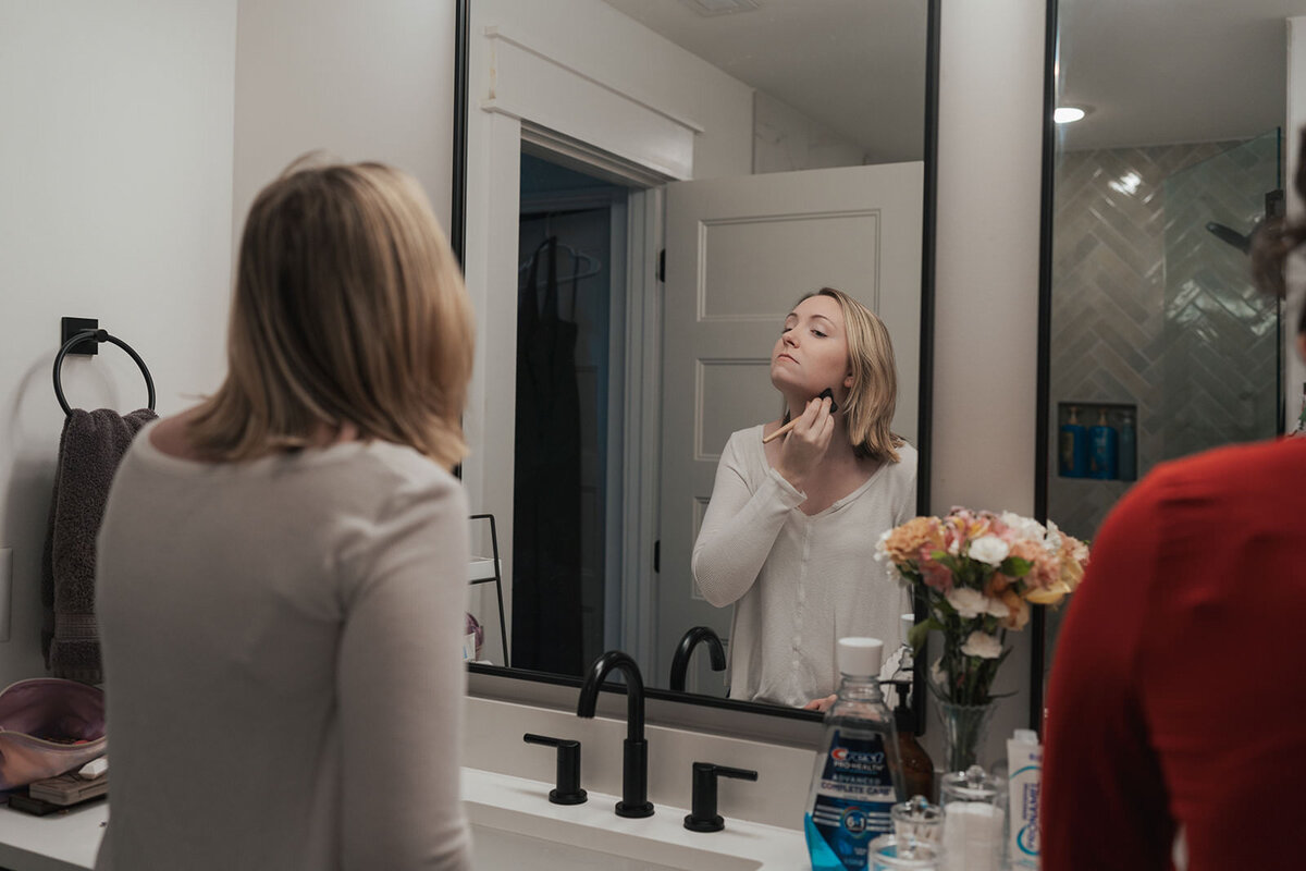 Woman applied makeup looking into the mirror