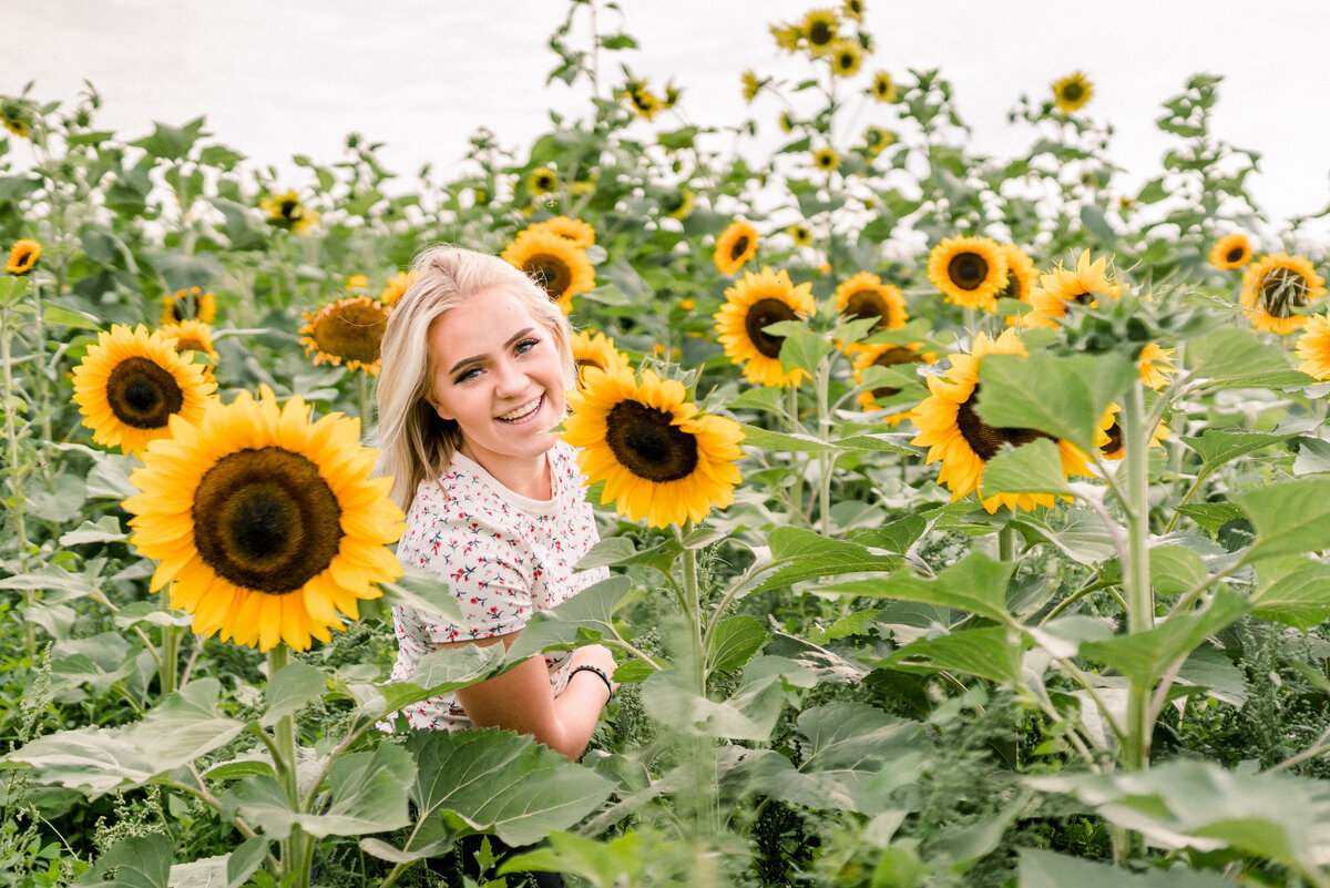 Austin Texas High school girl with casual outfit in the sunflowers for senior photos.