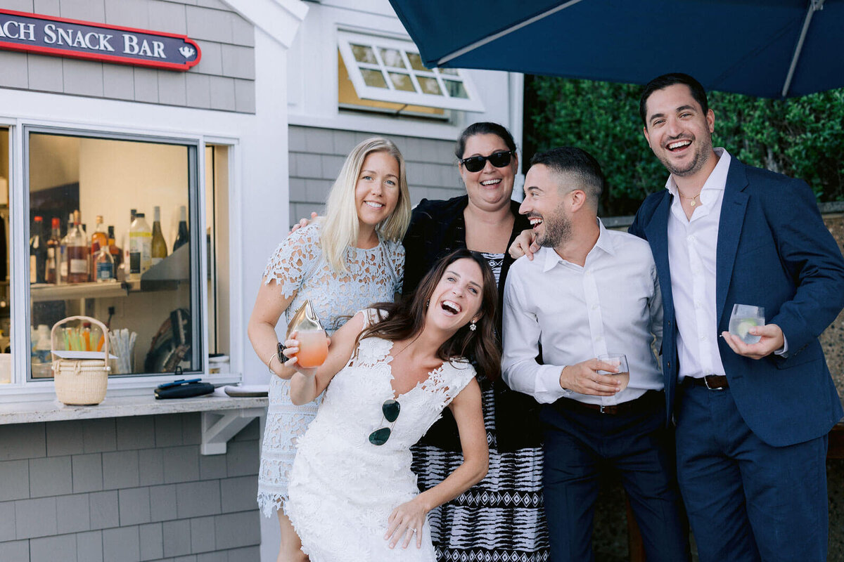 The bride and the groom, with three other people, are in front of a snack bar at Cape Cod, Osterville, MA.