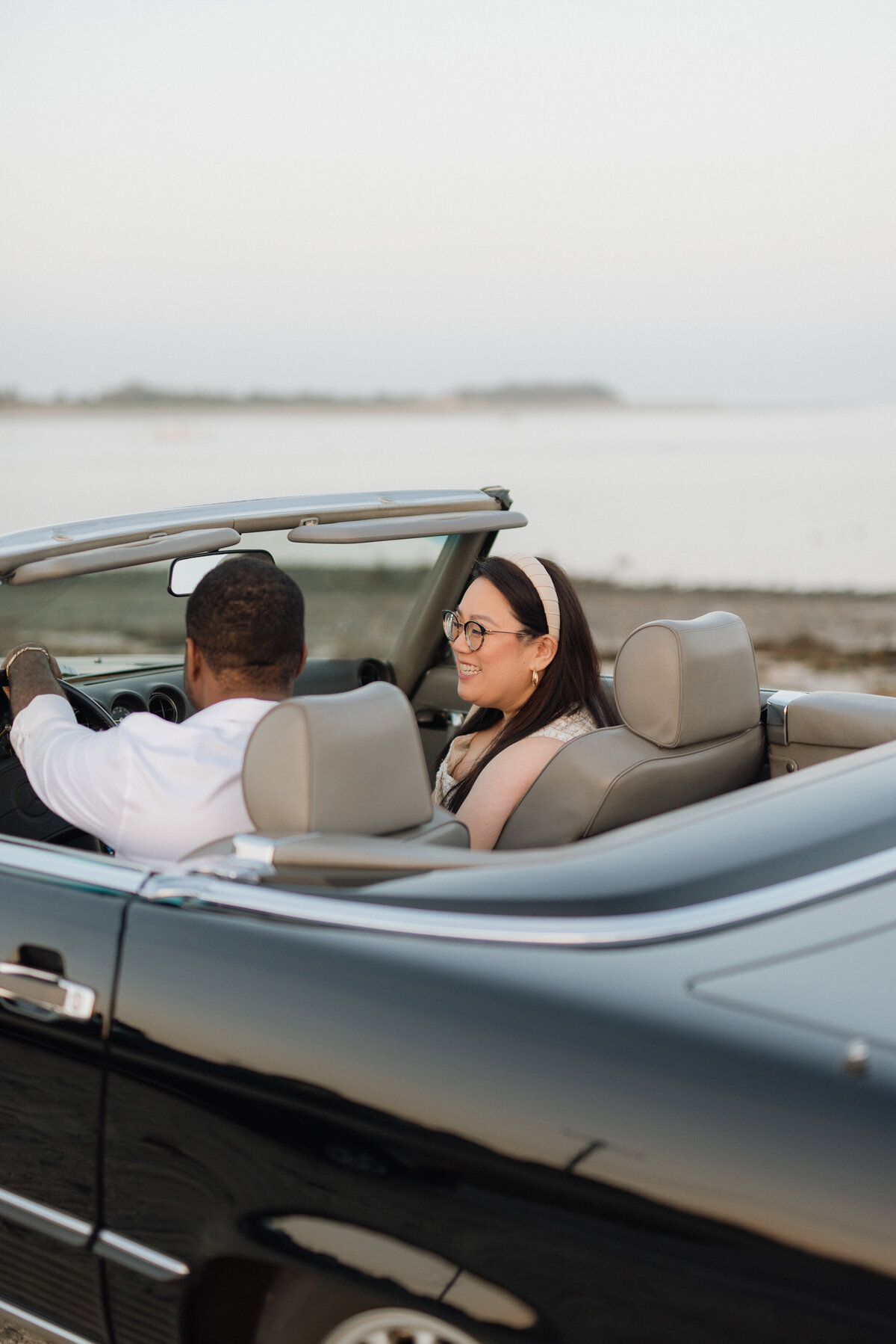 costal engagement session with vintage black mercedes benz  and a multicultural couple. asian women and black man in massachusetts