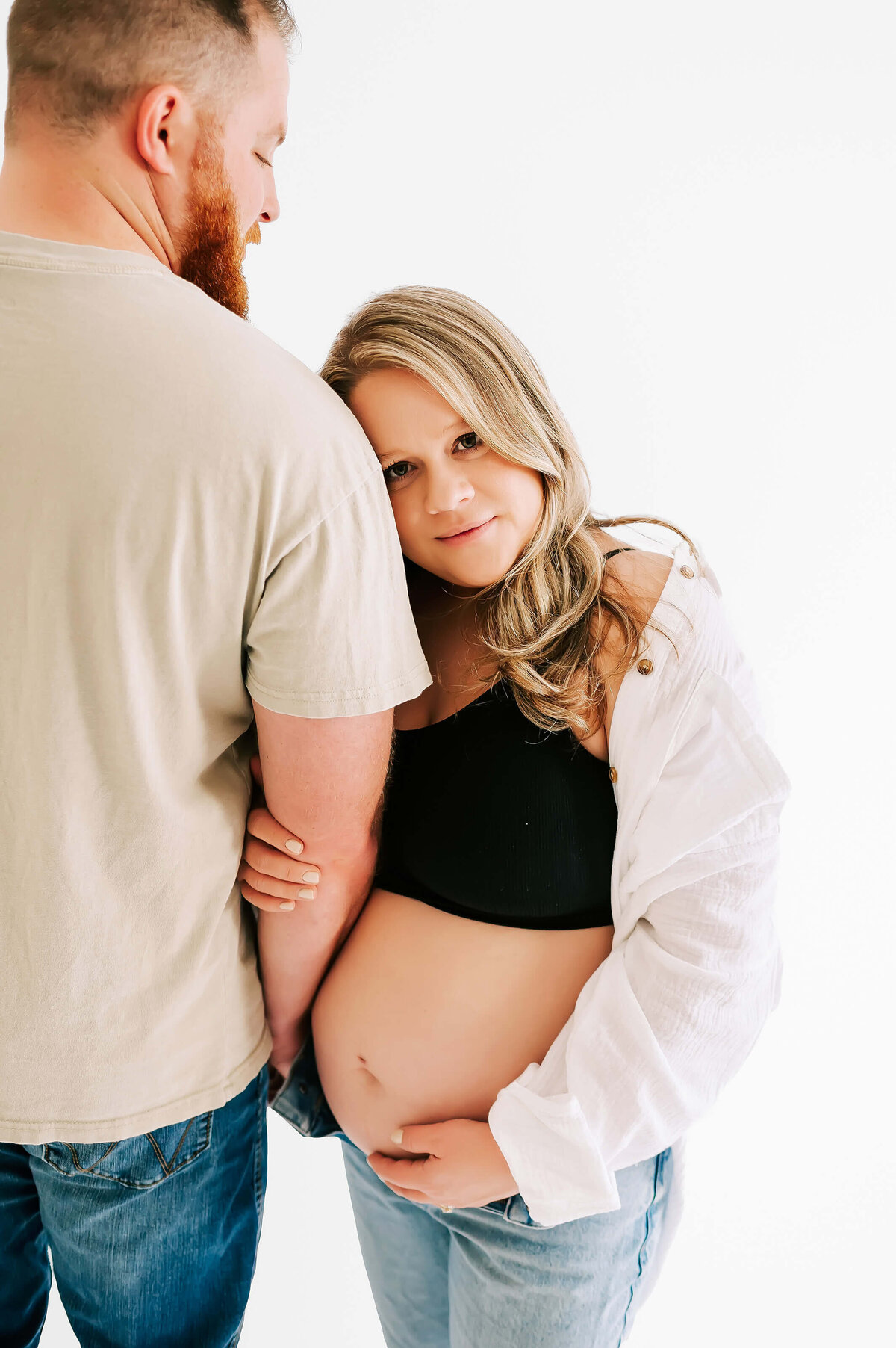 Pregnant mom leaning on husbands shoulder during Joplin MO maternity photographer Jessica Kennedy of The Xo Photography